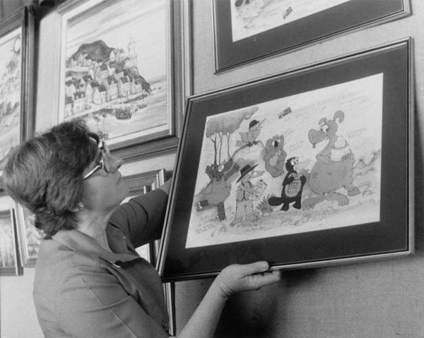 Anne Jackson, of the ACT Handicapped Citizens' Association, hanging one of Michael Salmon's Alexander Bunyip paintings to be auctioned at Koomarri Sheltered Workshop